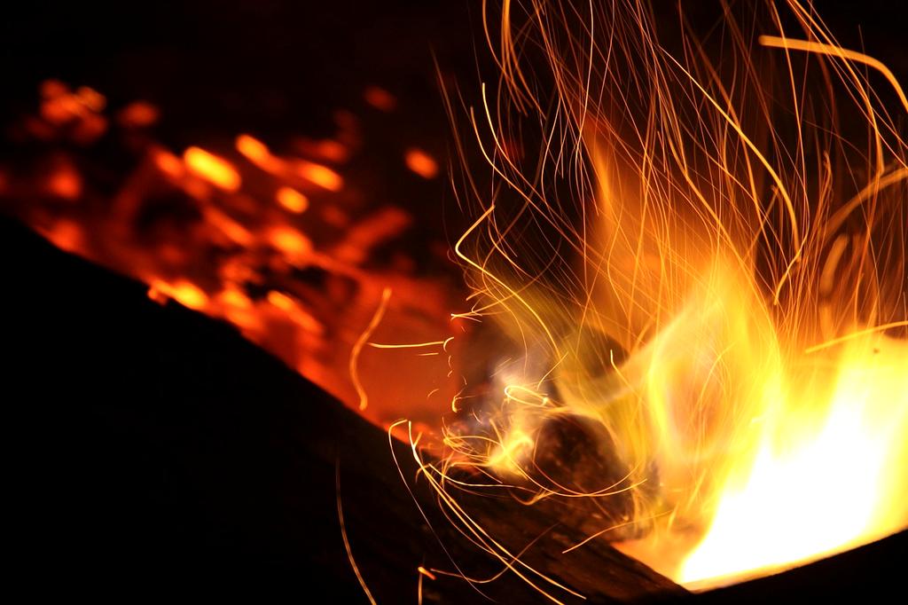 Family around a campfire under stars in a tent campsite