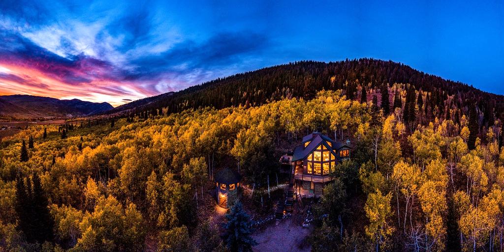Serene mountain landscape at sunset with a cozy cabin