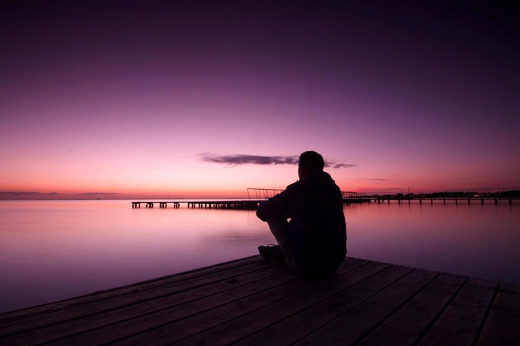 Aerial view of crystal clear blue water lake with a small wooden pier