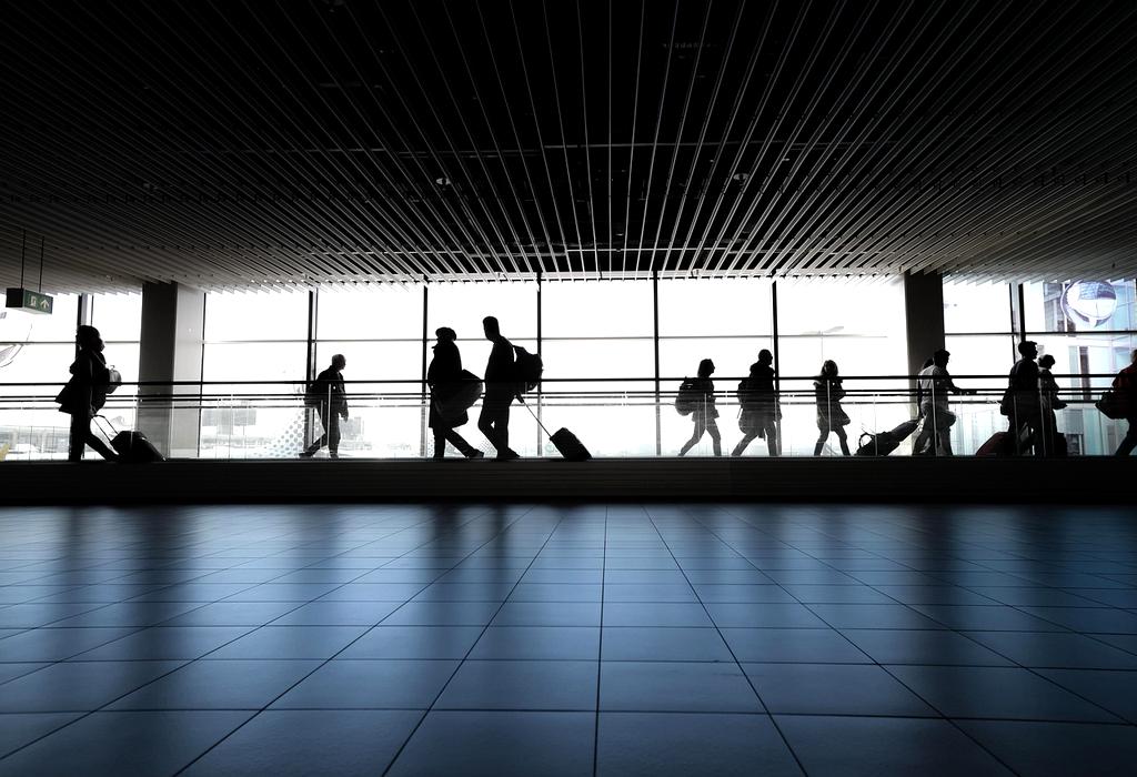 Sunset view of a busy airport terminal with departing flights